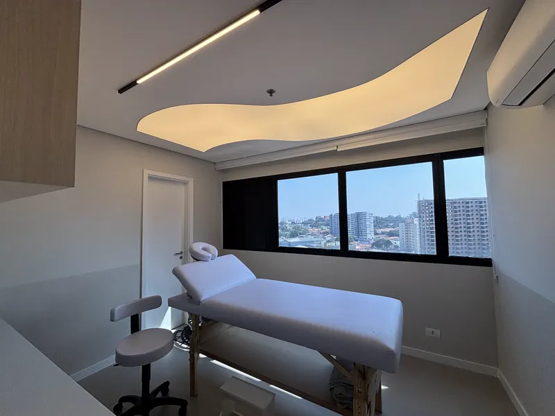 Sala de fisioterapia com maca e janela ampla